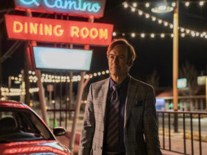 Pôster da se´rie Better Call Saul mostrando Jimmy andando com um grande letreiro luminoso atrás escrito "El Camino King Room"